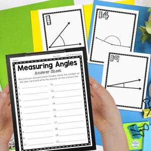 May include: A black clipboard with a white "Measuring Angles Answer Sheet" and several angle diagrams. The sheet includes lines for recording answers. Additional cards with angle diagrams are visible.