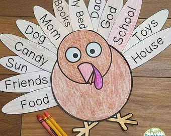 Puede incluir: Una manualidad de pavo de papel marrón y blanco con una cabeza grande y un cuello largo. El pavo tiene ojos grandes y una papada rosa. Las plumas del pavo están etiquetadas con palabras como "Mi cama", "Libros", "Mamá", "Perro", "Caramelos", "Sol", "Amigos", "Comida", "Dios", "Escuela", "Juguetes" y "Casa".
