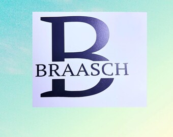 May include: A white rectangular decal featuring a large, dark blue capital letter B in a serif font. The word BRAASCH is printed in dark blue capital letters across the center of the letter B. The design has a smooth, matte finish throughout.