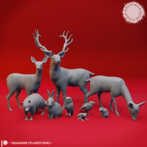 Puede incluir: Una colección de figuritas de animales grises, incluyendo un ciervo, un conejo, un mapache, un búho, un cuervo, una rana y un cervatillo. Las figuritas están dispuestas sobre una superficie roja.