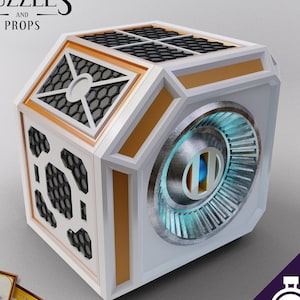 May include: A white cube with gold trim and a circular, metallic panel with a blue center. The cube has a honeycomb pattern on the sides. The cube is a prop for a game or puzzle.