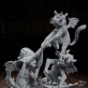 May include: A grey, 3D printed figurine of four small, winged demons, with horns and tails, standing on a pile of books. The demons are in a playful, chaotic pose, with one demon holding a book and another demon holding a spear.