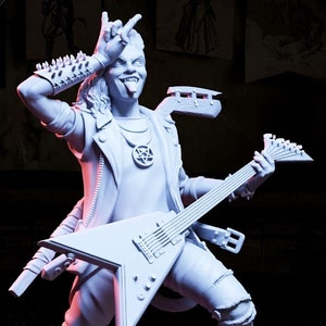 May include: A white painted figurine of a rock musician playing a guitar. The musician is wearing a leather jacket, ripped jeans, and boots. The figurine is standing on a small amplifier.