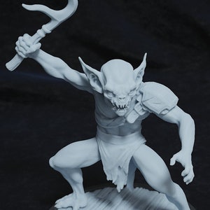 May include: A white painted miniature figurine of a goblin holding a trident-like weapon. The goblin is standing on a round base with a wood-grain texture.