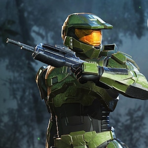 Puede incluir: Una figura de acción verde y negra de un personaje de la serie de videojuegos Halo. La figura lleva una armadura detallada y sostiene un rifle. La figura está de pie sobre una roca con un fondo de selva. El logotipo de Nom Nom Figures está en la esquina superior derecha.
