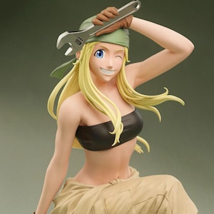 May include: A collectible anime-style figurine of a blonde character with blue eyes, wearing a green bandana, a black tube top, and beige pants. The character is winking and holding a silver adjustable wrench above their head with a brown gloved hand.