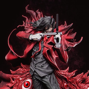 May include: A detailed figurine of a character with long black hair, wearing a red coat and holding two pistols. The figure is dressed in a gray suit, white gloves, and a red tie. The base features a red, textured design with multiple red eyes.