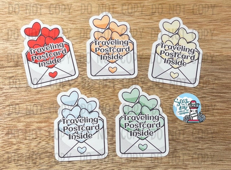 May include: Five colorful envelope stickers with the text "Traveling Postcard Inside" and hearts inside each envelope. The hearts are red, orange, yellow, green, and blue.