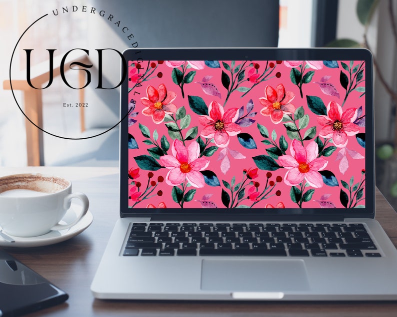 Op de afbeelding: Een laptop toont een levendig bloemenpatroon op het scherm. Het ontwerp toont roze en rode bloemen met groene bladeren en bessen tegen een roze achtergrond. Het logo "UGD" en "Est. 2022" zijn zichtbaar.