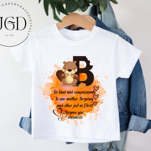 May include: White t-shirt with a brown cartoon beaver holding a branch. The beaver is in front of a large letter B with orange and brown watercolor splatters. The text "Be kind and compassionate to one another, forgiving each other just as Christ forgave you. Ephesians 4:32" is printed below the beaver.