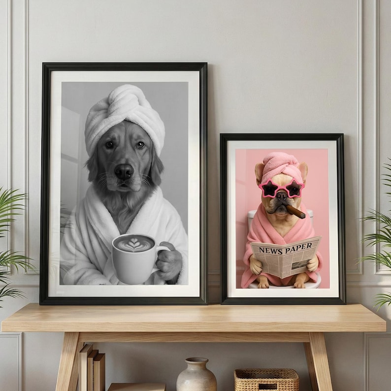 May include: Two framed wall art prints. The left print is a black and white portrait of a golden retriever wearing a towel wrap and robe, holding a coffee mug. The right print is a color portrait of a French bulldog in a pink towel and robe, wearing star-shaped sunglasses, holding a cigar, and reading a newspaper.