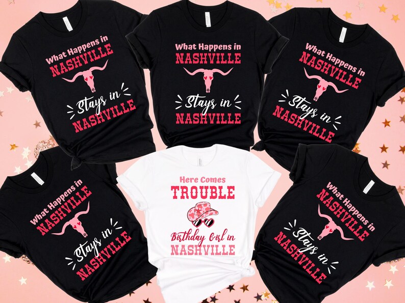 Pu&ograve; includere: Diverse magliette nere e bianche con la scritta "What Happens in Nashville Stays in Nashville". Una maglietta bianca mostra "Here Comes Trouble Birthday Girl in Nashville".