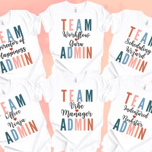 May include: Five white t-shirts with colorful text that reads "TEAM" and a different job title on each shirt. The job titles are "Director of Happiness", "Workflow Guru", "Scheduling Wizard", "Office Ninja", and "Vibe Manager".