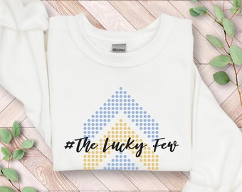 May include: White sweatshirt with a blue and yellow geometric design and the text "#The Lucky Few" printed on the front.