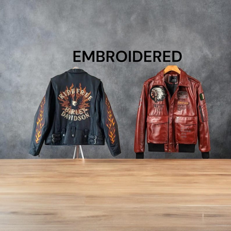 May include: Two embroidered leather jackets are displayed against a gray background. One is black with orange flame designs and Harley Davidson text. The other is a reddish-brown bomber jacket with patches and pockets. The word EMBROIDERED is above the jackets.