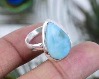 May include: A teardrop-shaped blue and white gemstone ring set in sterling silver.