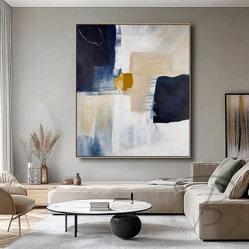 a living room filled with furniture and a painting on the wall