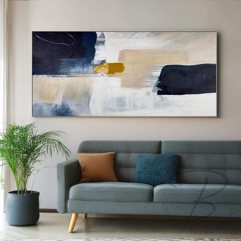 a living room with a couch and a painting on the wall