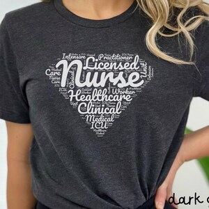 May include: A dark grey heather t-shirt with a white heart-shaped word cloud design that says "Licensed Nurse". The word cloud includes words like "Intensive Care", "Clinical", "ICU", "Healthcare", "Medical", and "Unit".