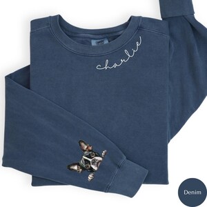 Pode incluir: Uma camisa de moletom azul denim com o nome "charlie" bordado na frente e um bulldogue franc&ecirc;s espiando da manga.