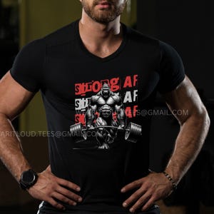 Pode incluir: Camiseta preta com um gorila levantando pesos e o texto "Strong AF" repetido tr&ecirc;s vezes.