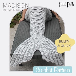 May include: A crochet mermaid tail blanket in a light gray color. The tail is laying on a gray lounge chair. The text "MADISON MERMAID TAIL" is at the top of the image. The text "Odd Dolli" is in the top right corner of the image. The text "BULKY & QUICK" is in a yellow circle in the bottom right corner of the image. The text "Crochet Pattern" is in a blue rectangle at the bottom of the image.