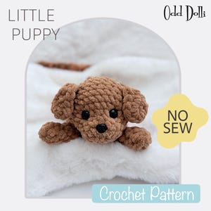 Puede incluir: Un juguete de cachorro de crochet marrón acostado sobre una manta blanca. El juguete tiene ojos negros y una nariz negra. El texto "LITTLE PUPPY" está en la esquina superior izquierda de la imagen. El texto "Odd Dolli" está en la esquina superior derecha de la imagen. El texto "NO SEW" está en un círculo amarillo en la esquina inferior derecha de la imagen. El texto "Crochet Pattern" está en un rectángulo azul claro en el centro inferior de la imagen.