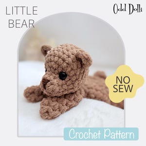 Könnte beinhalten: Ein gehäkeltes braunes Stofftier in Form eines Bären mit schwarzen Augen. Der Bär liegt auf einer weißen Oberfläche. Der Text "LITTLE BEAR" befindet sich in der oberen linken Ecke des Bildes. Der Text "Odd Dolli" befindet sich in der oberen rechten Ecke des Bildes. Der Text "NO SEW" befindet sich in einem gelben Kreis in der unteren rechten Ecke des Bildes. Der Text "Crochet Pattern" befindet sich in einem blauen Rechteck in der unteren Mitte des Bildes.