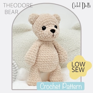 May include: A beige crocheted teddy bear with black eyes and a black nose. The bear is standing on a white surface. The text "THEODORE BEAR" is at the top left. The text "Odd Dolli" is at the top right. The text "LOW SEW" and "Crochet Pattern" are at the bottom.