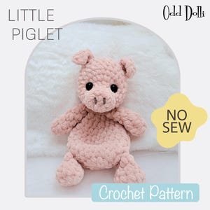 May include: A pink crocheted piglet toy with black eyes and a brown snout. The toy is sitting on a white fluffy blanket. The text "Little Piglet" is in the top left corner of the image and "Odd Dolli" is in the top right corner. The text "No Sew Crochet Pattern" is in the bottom center of the image.