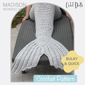 Peut inclure: Une couverture queue de sirène en crochet gris clair. La queue présente un motif en forme d'éventail. La couverture est étiquetée "MADISON MERMAID TAIL" et "Crochet Pattern". Les mots "BULKY & QUICK" sont également visibles.