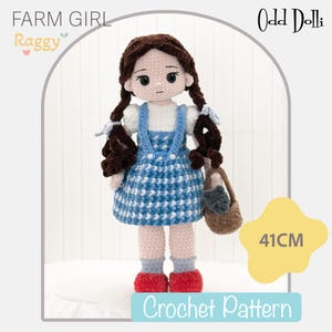Könnte beinhalten: Eine 41 cm große Häkelpuppe mit dunkelbraunem Haar in Zöpfen, bekleidet mit einem weißen Kurzarm-Oberteil, einem blau-weiß karierten Trägerkleid, grauen Socken und roten Schuhen. Die Puppe hält einen kleinen braunen Korb. Text: FARM GIRL, Odd Dolli, 41CM, Crochet Pattern.