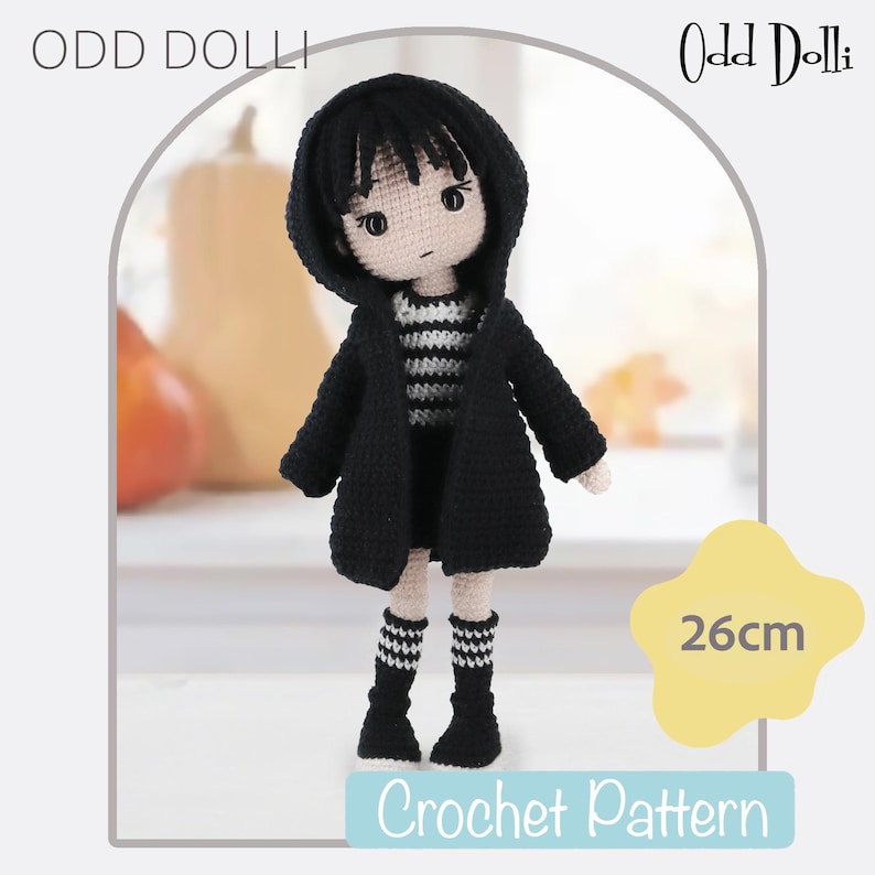 May include: A 26cm tall crocheted doll with black hair, wearing a black hooded cardigan over a black and white striped shirt, a black skirt, and black and white striped socks. The text ODD DOLLI and Crochet Pattern are visible on the image.