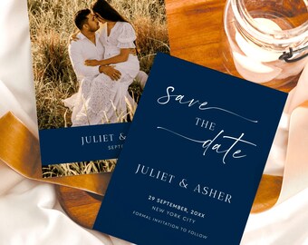 May include: A navy blue save the date card with white text. The card says "Save the date" in a script font and includes the couple's names, "Juliet & Asher", the date "29 September, 20XX", and the location "New York City". The card also includes the text "Formal invitation to follow".