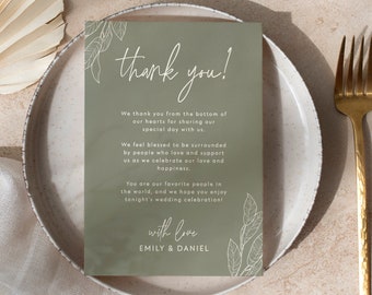 May include: A green thank you card with white text and a floral design. The text reads "thank you!" and "We thank you from the bottom of our hearts for sharing our special day with us. We feel blessed to be surrounded by people who love and support us as we celebrate our love and happiness. You are our favourite people in the world, and we hope you enjoy tonight's wedding celebration! with love EMILY & DANIEL"