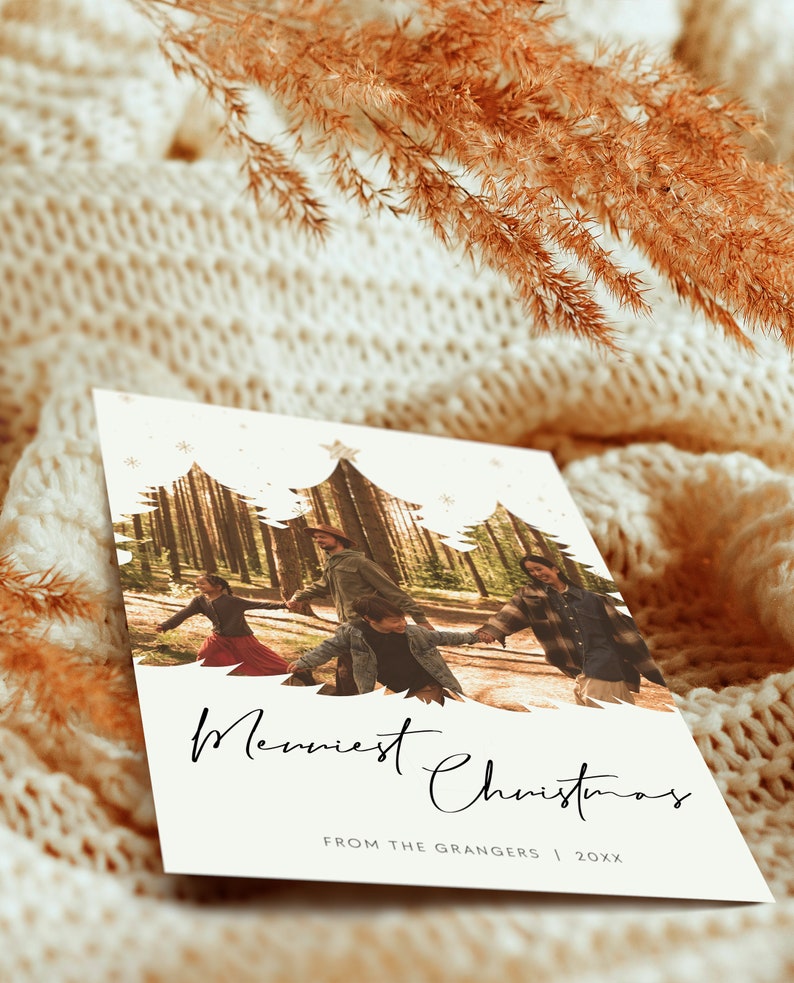 May include: A white Christmas card with a photo of a family of four walking through a forest. The photo is framed by a silhouette of three Christmas trees. The text "Merriest Christmas" is written in black cursive script. The text "From the Grangers | 20XX" is written in black below the photo.