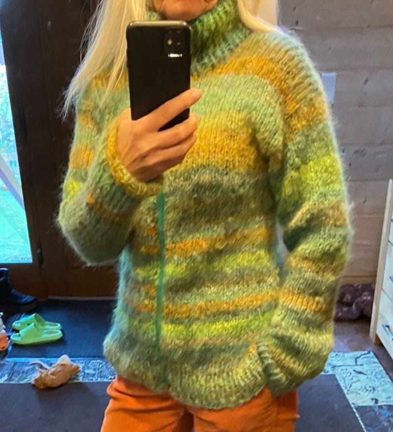 May include: A green, yellow and orange striped fuzzy sweater with a high neck.