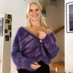 Puede incluir: Un c&aacute;rdigan de color morado y rosa con un cierre de bot&oacute;n &uacute;nico. El c&aacute;rdigan est&aacute; hecho de un material suave y esponjoso y tiene un ajuste holgado.