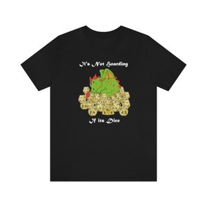 May include: Black t-shirt featuring a green dragon sleeping on a pile of dice. The text on the shirt reads "It's Not Hoarding If It's Dice."