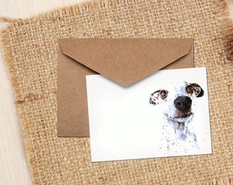May include: A white and black spotted dog with brown eyes looks directly at the camera. The dog's nose is black and the background is white.
