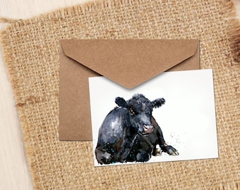 Puede incluir: Una pintura de acuarela de una vaca negra acostada sobre un fondo blanco. La vaca tiene una mancha blanca en la nariz y mira al espectador.