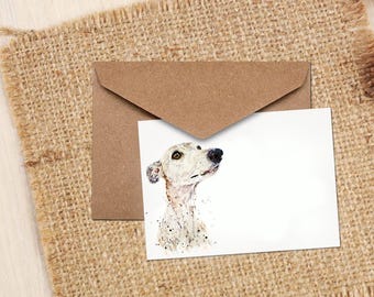 May include: A greeting card featuring a watercolor illustration of a dog's head, with a brown envelope behind it. The dog is white with black spots and a black nose. The card and envelope are on a burlap surface.