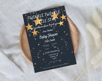Peut inclure: Une invitation à une baby shower bleu marine avec des étoiles dorées et du texte. L'invitation indique "Twinkle Twinkle Little Star" et comprend les détails de l'événement. L'invitation est sur une assiette en bois.