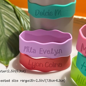 May include: Five colorful silicone wristbands with names printed on them. The wristbands are 2.5 inches in diameter and come in a variety of colors, including pink, purple, red, green, and blue. The names on the wristbands are "Dolcie M", "Mila Evelyn", "Lyon Colina", "Maria", and "Harri".