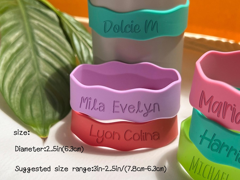 May include: Five colorful silicone wristbands with names printed on them. The wristbands are 2.5 inches in diameter and come in a variety of colors, including pink, purple, red, green, and blue. The names on the wristbands are "Dolcie M", "Mila Evelyn", "Lyon Colina", "Maria", and "Harri".