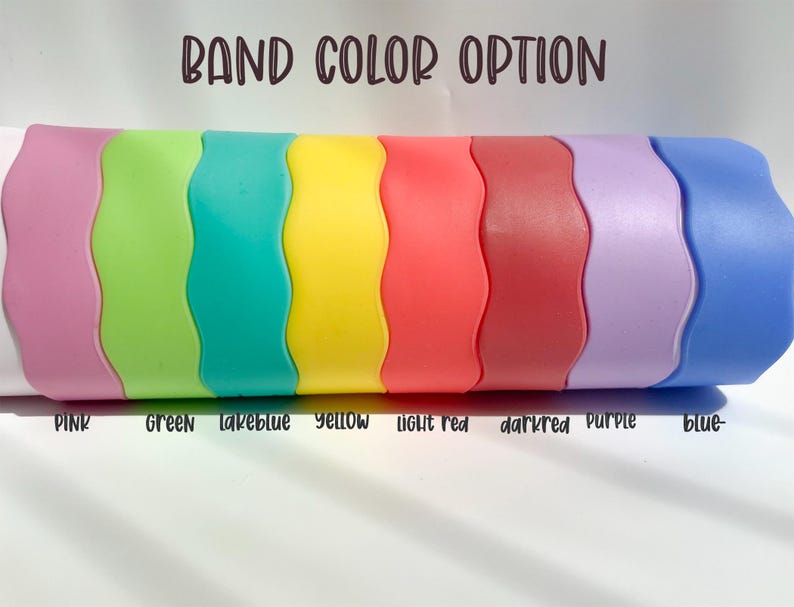 May include: A row of eight silicone wristbands in different colors: pink, green, teal, yellow, light red, dark red, purple, and blue. The text "BAND COLOR OPTION" is at the top of the image. The colors are labeled below the bands.