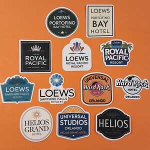 May include: A collection of ten colourful hotel logo stickers. The stickers feature the names of various hotels, including Loews, Hard Rock, and Universal Studios.