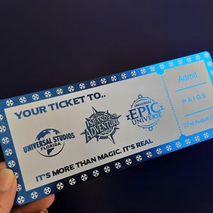 Pu&ograve; includere: Un biglietto argentato con accenti blu per l'ammissione a Universal Studios Islands of Adventure e Universal's Epic Universe. Il biglietto recita "Your Ticket To..." e "It's More Than Magic. It's Real." Il biglietto &egrave; per Paige ed &egrave; datato 22 agosto 2025.