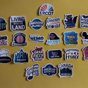 May include: A collection of 18 colourful stickers featuring various Disney and Pixar characters and attractions. The stickers are arranged in a grid on a yellow background. Some of the stickers feature text, such as "Spaceship Earth", "Living with the Land", "Soarin' around the World", "Test Track", "Journey into Imagination", "The Sea's with Nemo and Friends", "Journey of Water", "Gran Fiesta Tour", "Beauty and Beast Sing-Along", "Talk with Crush", "Impressions de France", "Reflections of China", "Luminous Symphony of Us", "The American Adventure", "Canada Far and Wide", and "Mission Space".