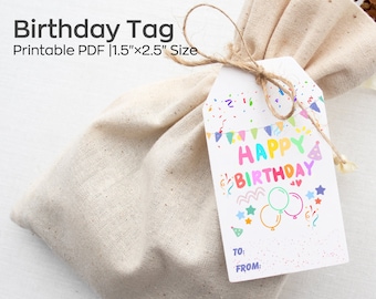 Pode incluir: Uma etiqueta de presente branca com confete colorido, balões e o texto "HAPPY BIRTHDAY" impresso nela. A etiqueta está amarrada com um barbante a uma pequena bolsa de lona branca. A etiqueta mede 1,5 polegadas por 2,5 polegadas.